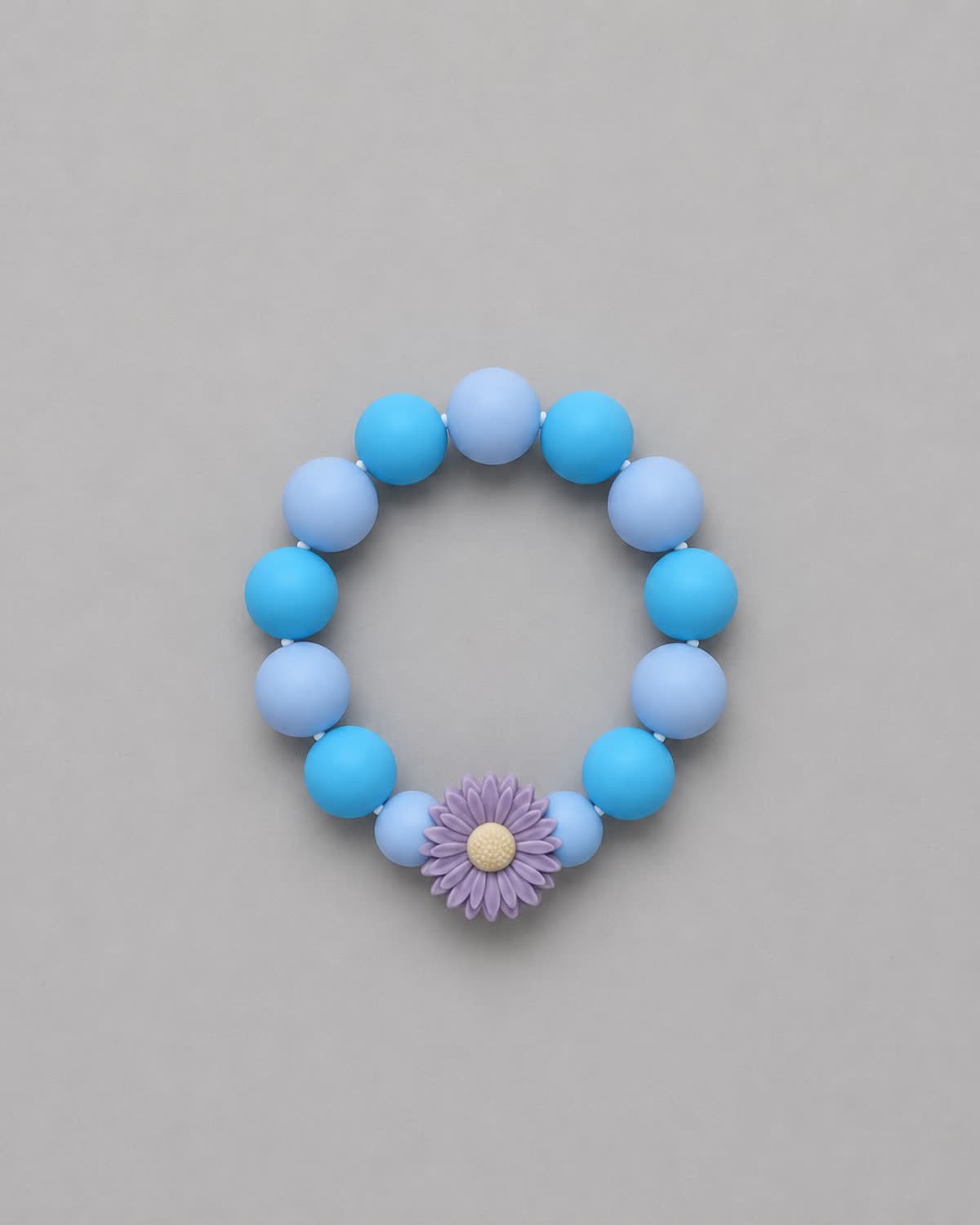 Anneau de dentition Fleur Azur : perles bleues et bleu clair, marguerite lilas au cœur jaune