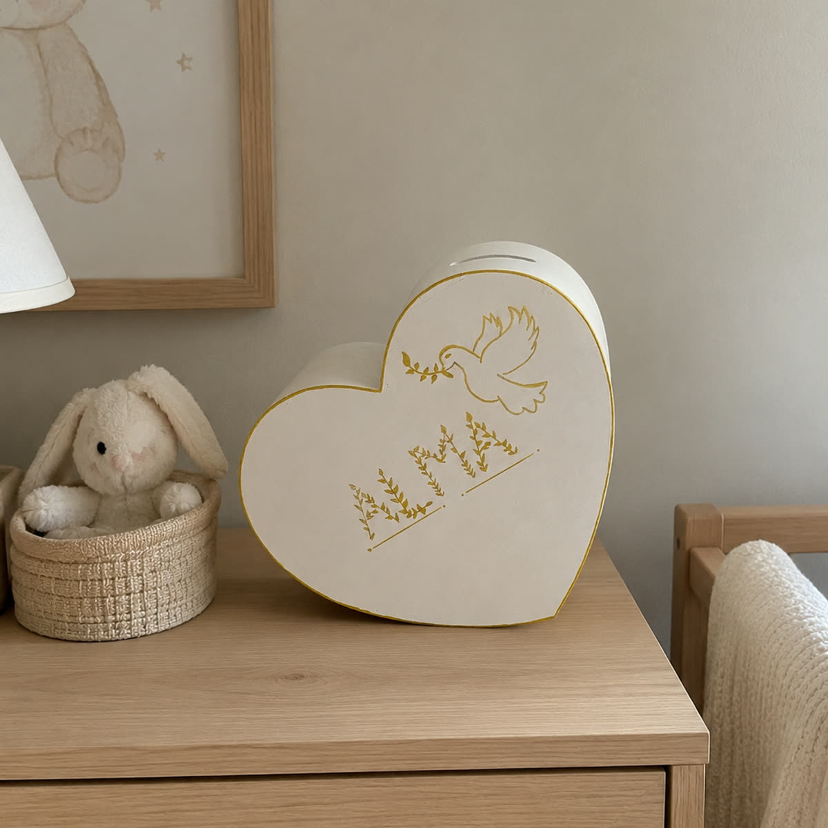Coffre Cœur à souvenirs en bois blanc au prénom doré, posé sur une commode dans une chambre de bébé