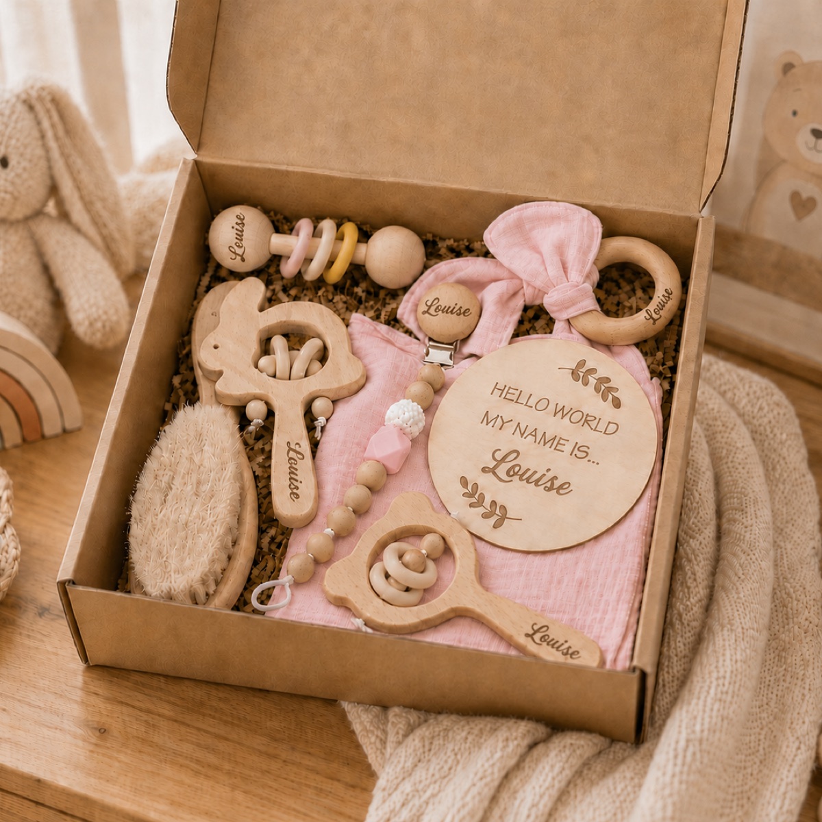 Coffret naissance personnalisé rose posé sur une commode dans une chambre de bébé
