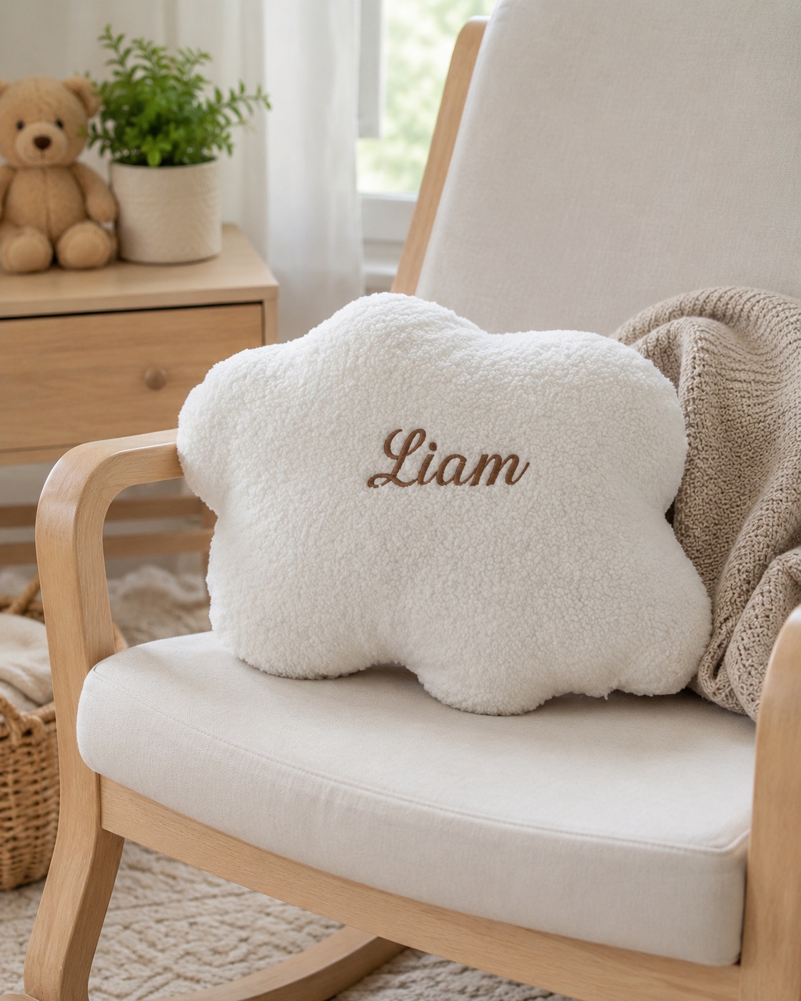 Coussin nuage personnalisé brodé d’un prénom, posé sur un fauteuil dans une chambre d’enfant